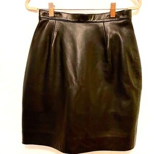 Paris Paris Black knee/mini length leather skirt w back vent at hem zip closure